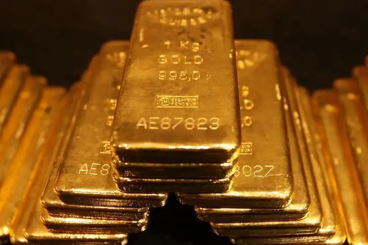 Gold rises 1% as dollar slips, on course for weekly gain