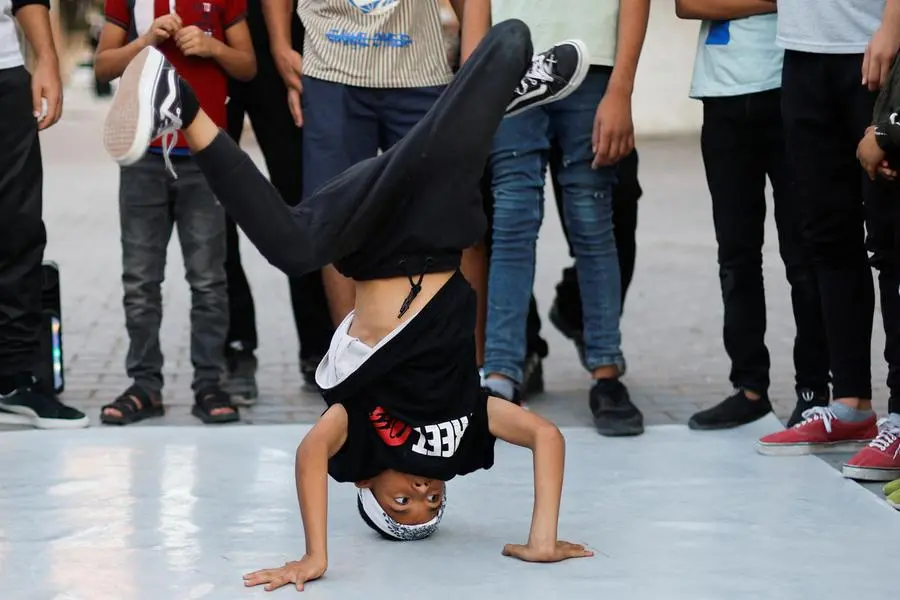 A Palestinian boy performs breakdance at a street in Nusseirat refugee camp in central Gaza Strip, October 14, 2022. REUTERS/Ibraheem Abu Mustafa