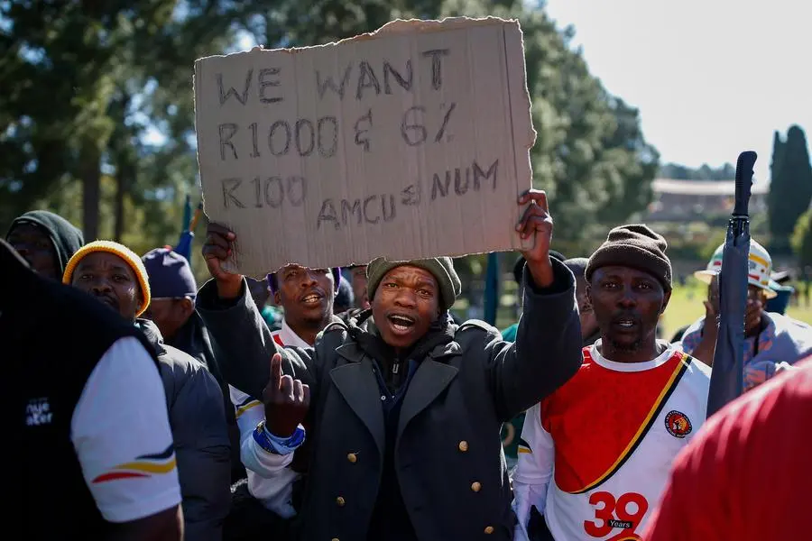 Striking mineworkers affiliated to the South Africa\\'s National Union of Mineworkers (NUM) and the Association of Mineworkers and Construction Union (AMCU) hold a placard while they sing and chant at the lawns of the Union Buildings in Pretoria on May 23, 2022. - The workers gathered at the official seat of South African government while on a three month long strike and are demanding an increase of R1,000 per month while their employer Sibanye-Stillwater is only offering a rise of R850. (Photo by Phill Magakoe / AFP) Image used for illustrative purpose.
