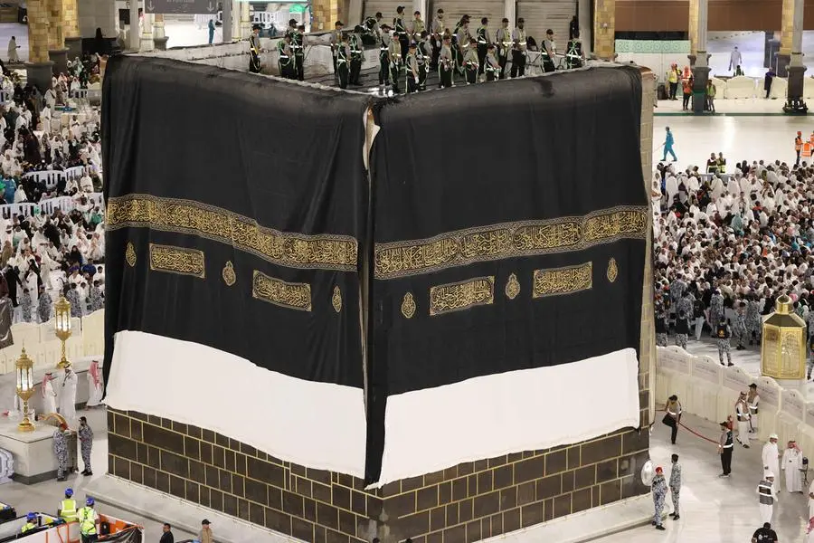 Saudi workers adjust the new Kiswa, the protective cover that engulfs the Kaaba which is made from black silk and gold thread and is embroidered with Koran verses, in Saudi Arabia\\'s holy city of Mecca, on July 6, 2024. (Photo by Abdel Ghani BASHIR / AFP) , Agence France-Presse (AFP)/AFP