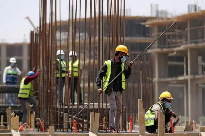 Image used for illustrative purpose Workers wearing protective face masks stand on a building under construction in the New Administrative Capital (NAC), east of Cairo, amid concerns about the spread of the coronavirus disease (COVID-19), in Egypt May 6, 2020. , Mohamed Abd El Ghany