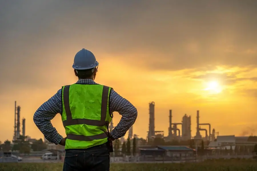 Asian engineers looking at site in oil and gas refinery or Petrochemical factory during sunrise, industrial concept. , Getty Images/Getty Images