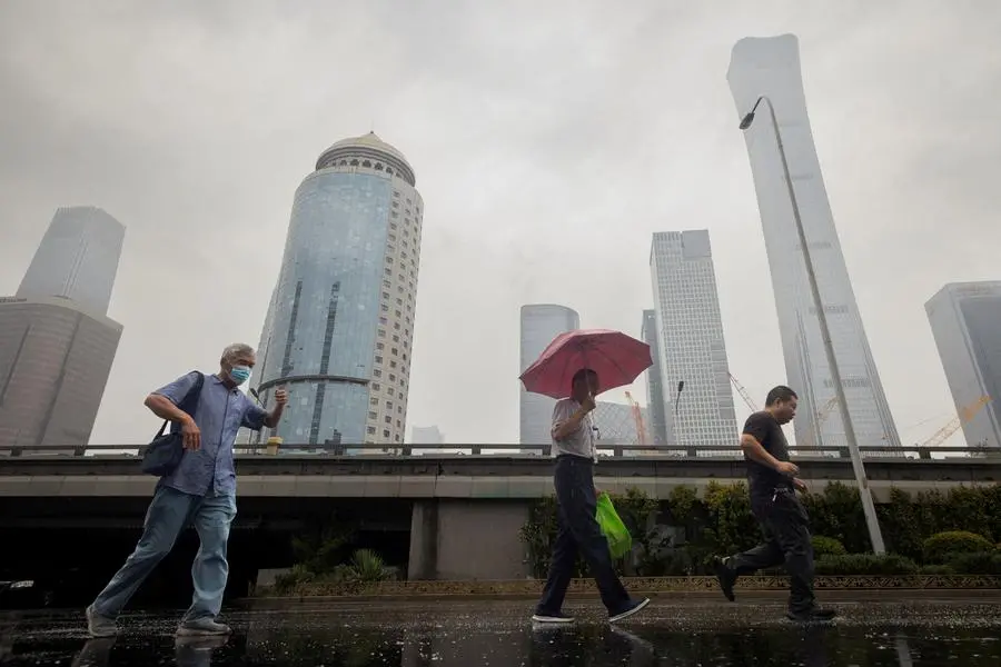 FILE PHOTO: People walk in the Central Business District on a rainy day in Beijing, China. REUTERS/Thomas Peter/File Photo , Reuters/REUTERS