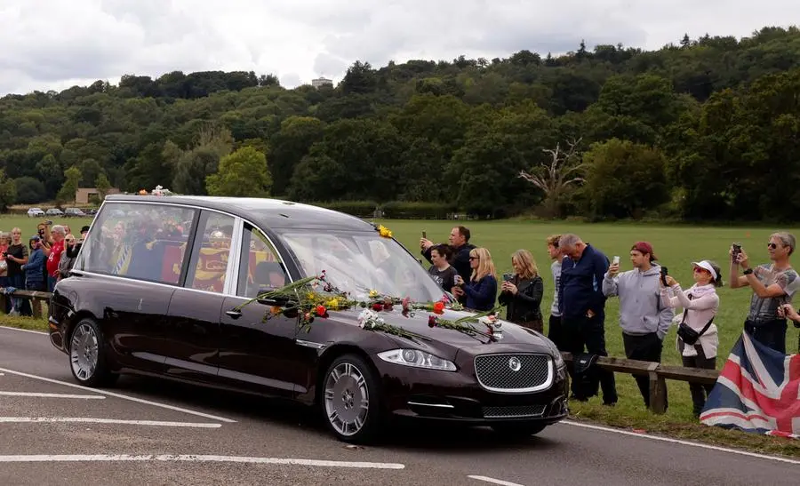 Spectators take pictures as the hearse carrying the coffin of Queen Elizabeth travels to Windsor, on the day of the state funeral and burial of Britain's Queen Elizabeth, in Runnymede, Britain, September 19, 2022 REUTERS/Andrew Couldridge