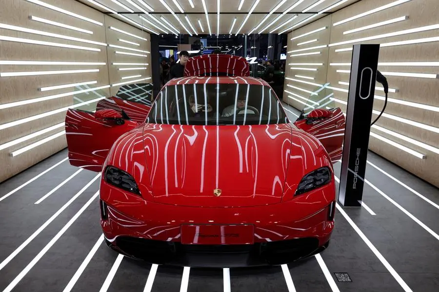 FILE PHOTO: People look at the Porsche Taycan GTS electric vehicle (EV) during a media day for the Auto Shanghai show in Shanghai, China April 23, 2025. REUTERS/Go Nakamura. , Reuters