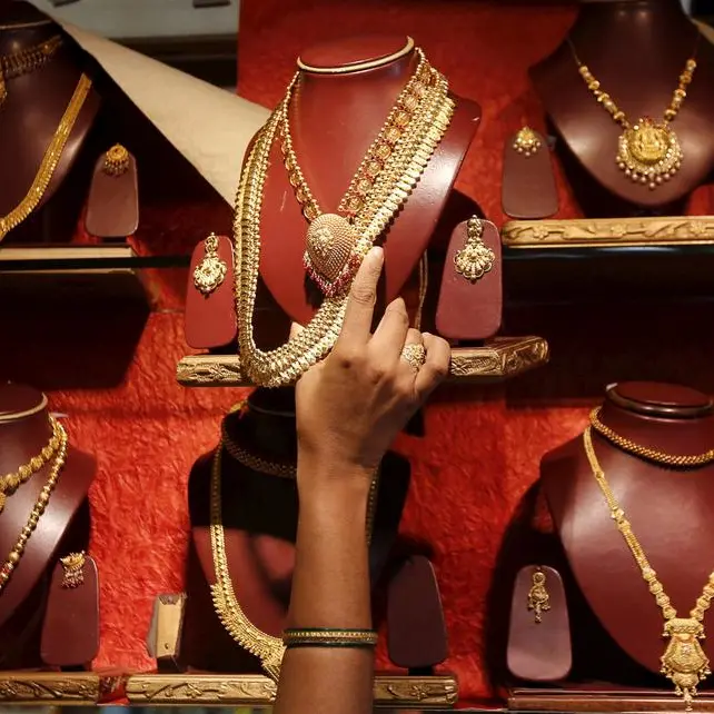 Gold rises over 1% as dollar rally pauses, trade jitters resurface