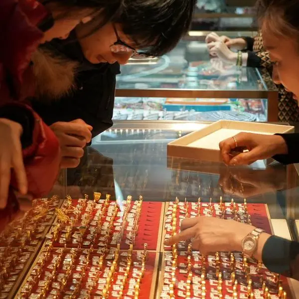 Gold slips on firmer dollar, but set for best month since 1980