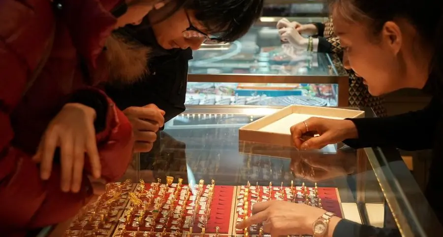 Gold slips on firmer dollar, but set for best month since 1980