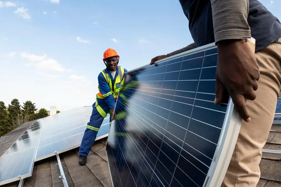 Team of blue collar workers installing solar panel on roof of building. Image used for illustrative purpose. Getty Images , Getty Images