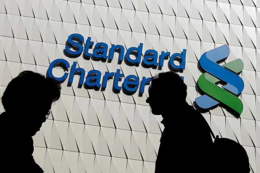 FILE PHOTO: Passersby walk in front of the main branch of Standard Chartered in Hong Kong, January 8, 2015. REUTERS/Bobby Yip. , Reuters