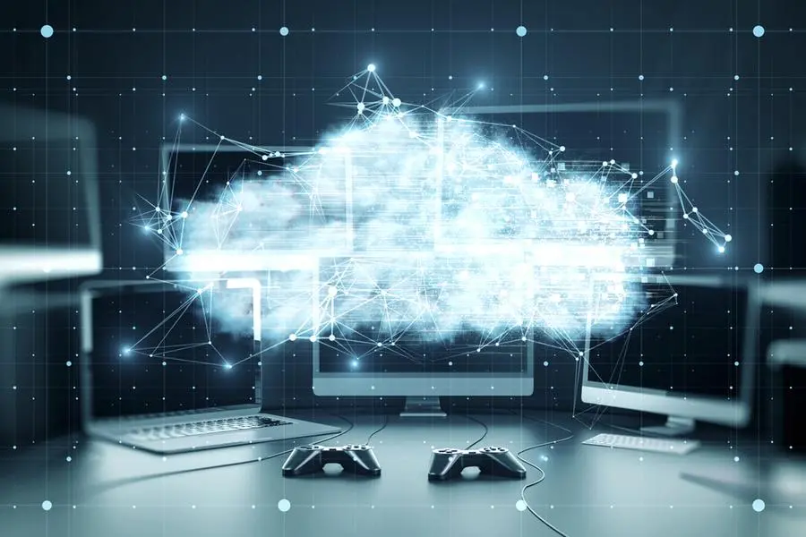 Close up of various computer monitors on desktop with digital glowing polygonal cloud mesh on blurry background. Storage technology concepts transfer data to cloud computing platforms. Image used for illustrative purpose. Image courtesy: Getty Images/ Peshkov