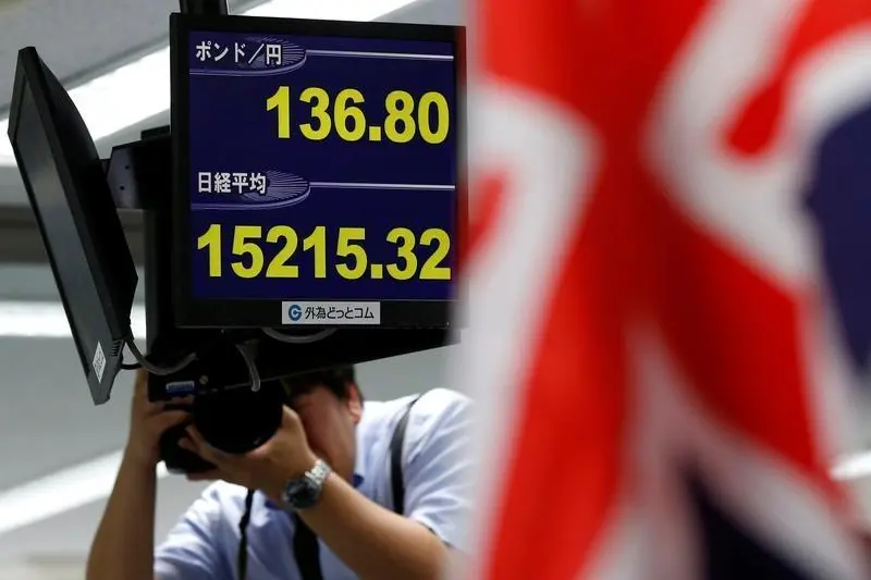 A news photographer take photos of monitors displaying the Japanese yen\\'s exchange rate against British pound (top) and Japan\\'s Nikkei share average at a foreign exchange trading company in Tokyo, Japan, June 27, 2016. REUTERS/Toru Hanai - RTX2ID8O , Reuters Images