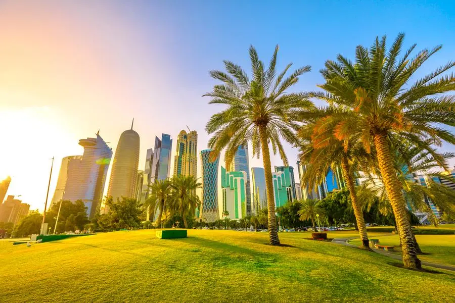 Palm trees in West Bay park along corniche promenade with glassed high rises at sunset on background. Doha skyline, Qatar, Middle East, Arabian Peninsula in Persian Gulf. Scenic urban cityscape. Image used for illustrative purpose. Image courtesy: Benny Marty/ Getty Images