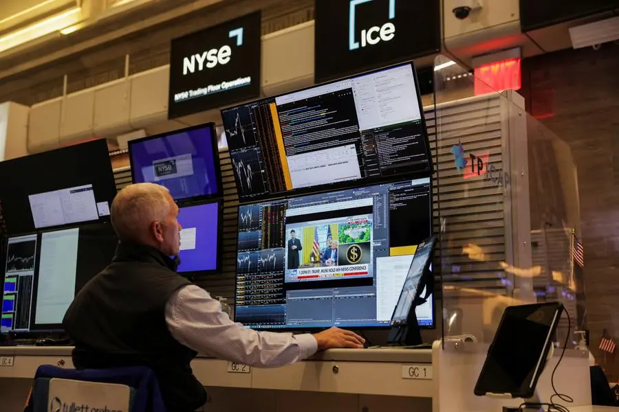 A screen shows Tesla CEO Elon Musk and U.S. President Donald Trump, as a futures-options trader works on the floor of the the New York Stock Exchange (NYSE) in New York City, U.S., May 30, 2025. REUTERS/Jeenah Moon. , Reuters