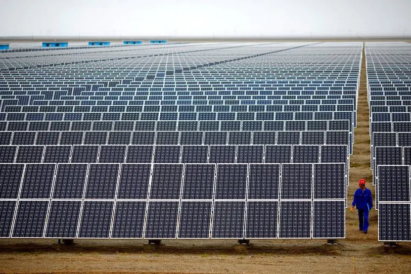 FILE PHOTO: A worker inspects solar panels at a solar farm in Dunhuang, 950km (590 miles) northwest of Lanzhou, Gansu Province September 16, 2013. REUTERS/Carlos Barria. , Reuters