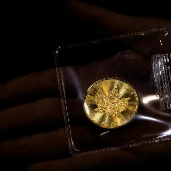Gold falls from two-week highs as dollar ticks up