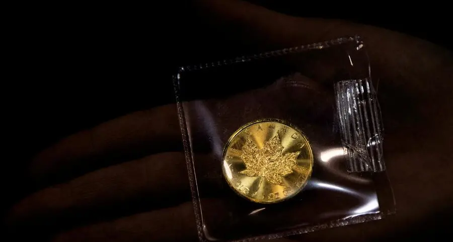 Gold falls from two-week highs as dollar ticks up