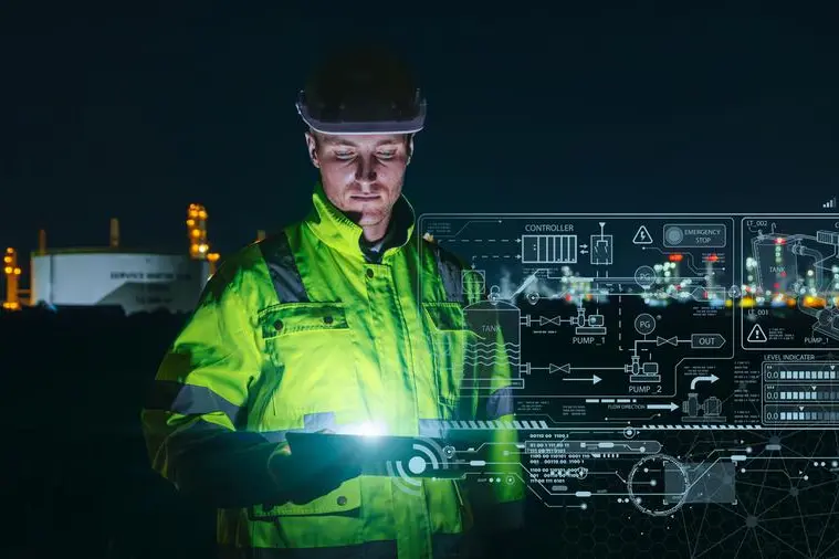 Modern technology oil and gas refinery engineer worker using advance digital device monitor service in petroleum industry pipe plant. Image used for illustrative purpose. Image courtesy: Getty Images/ CoffeeKai , Getty Images