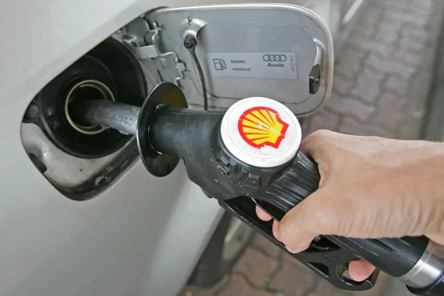 FILE PHOTO: A driver fills up with petrol at a Shell petrol station in southern England, September 12, 2005. REUTERS/Toby Melville. , Reuters
