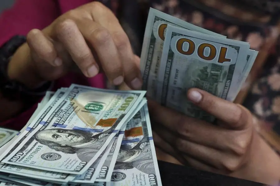 A teller counts U.S. dollar bank notes at a money changer in Jakarta, Indonesia, April 9, 2025. Picture taken through glass. REUTERS/Willy Kurniawan. , Reuters