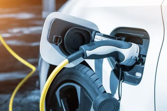 Close-up modern electric plug-in hybrid car parked near fast charger charging station point in center street old European city. Eco friendly green energy vehicle. Zero emission transport technology. Image courtesy: Kirill Gorlov - stock.adobe.com Image used for illustrative purpose.