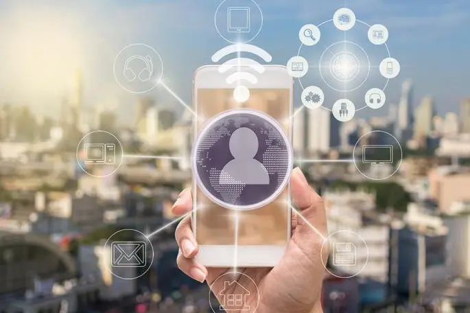 holding smart phone showing the mobile payments and online shopping with moni channel over the cityscape background,business omni channel or multi Channel concept , Getty Images/Getty Images
