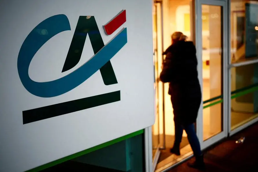 FILE PHOTO: A woman walks past a Credit Agricole logo as she enters a bank office in Reze, near Nantes, France, February 8, 2024. REUTERS/Stephane Mahe. , Reuters