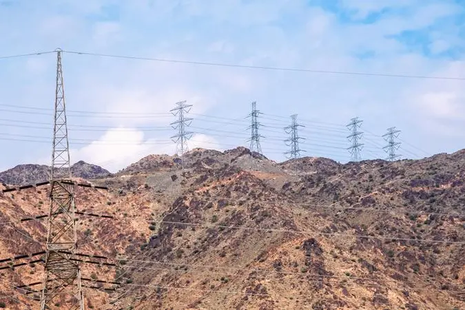 Medina, Saudi Arabia - December 22, 2022: High-voltage power lines dominate the arid landscape against a backdrop of rugged mountains. Image used for illustrative purpose. Getty Images , Getty Images