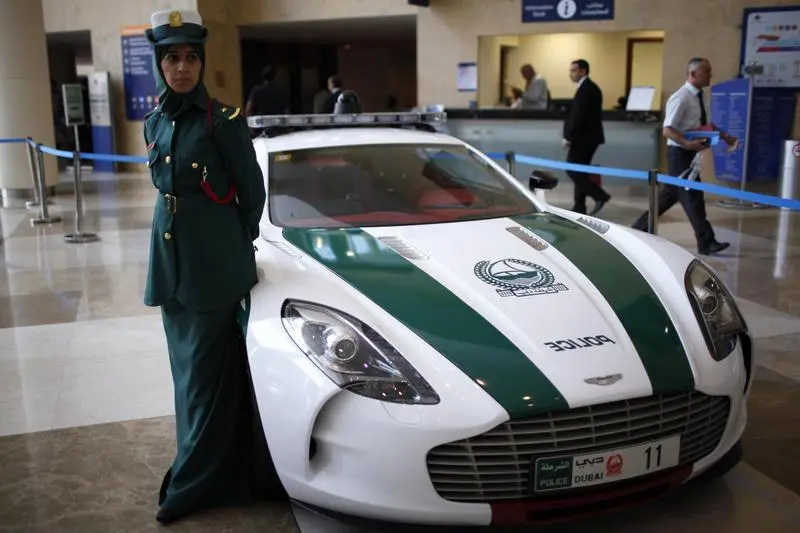 A police officer stands near an Aston Martin car used by Dubai police, during the Arabian Travel Market exhibition in Dubai , Reuters Images/Ahmed Jadallah