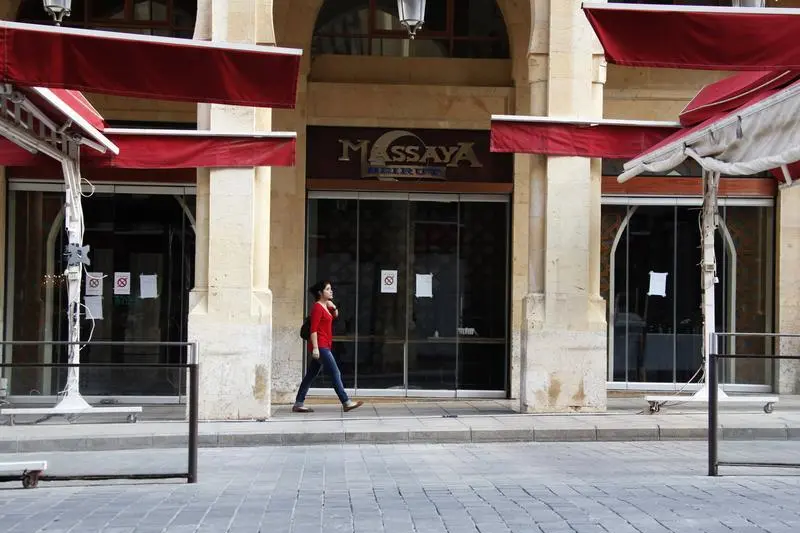 Image used for illustrative purpose. A woman walks past a closed restaurant in downtown Beirut. , Reuters Images/Mohamed Azakir