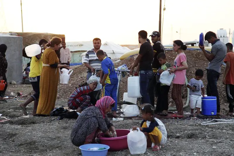 Syrian refugees, who fled the violence in Syria, use containers to collect water at the Arbat refugee camp in Sulaimaniya , Reuters Images/STRINGER Iraq