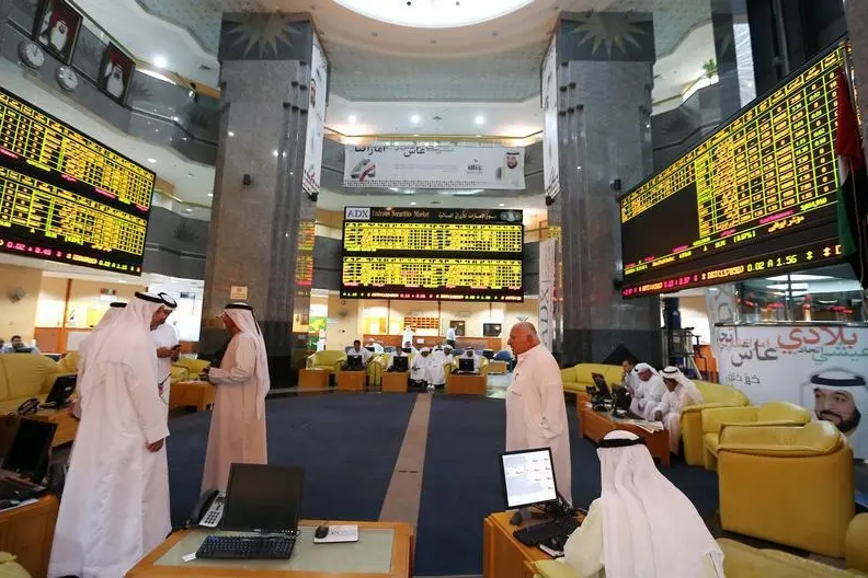 Investors monitor screens displaying stock information at the Abu Dhabi Securities Exchange June 25, 2014. Image for illustrative purposes