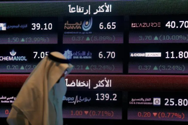 An investor walks past a screen displaying stock information at the Saudi Stock Exchange (Tadawul) in Riyadh, Saudi Arabia. Image used for illustrative purpose. , Faisal Al Nasser  