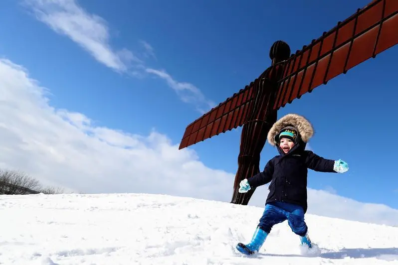 A boy plays in the snow next to the Angel of the North statue near Gateshead, Britain, February 27, 2018.  , Reuters Images/Scott Heppell 