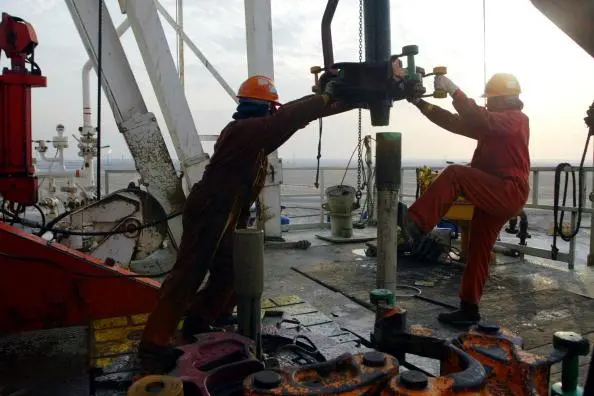 Oil rig workers work on the ChevronTexaco drilling platform January 15, 2003 near the Saudi Arabian border, Kuwait. Image used for illustrative purposes Getty Images. Joe Raedle