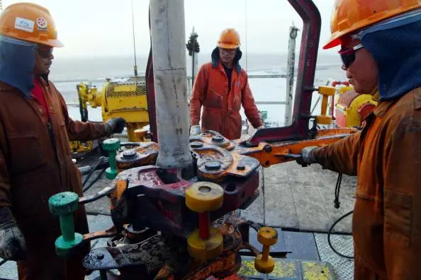 Image used for illustrative purpose. Oil rig workers attach another piece of pipe onto the ChevronTexaco drilling platform January 15, 2003 near the Saudi Arabian border, Kuwait. , Getty Images/Joe Raedle