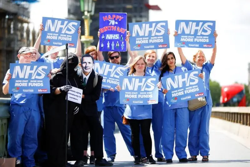 NHS staff hold banners and placards during a posed protest in central London, June 21, 2018. , Reuters Images/Henry Nicholls