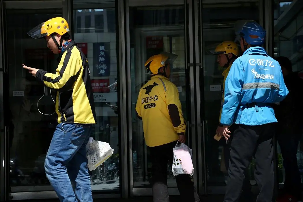 FILE PHOTO - Drivers of food delivery service Ele.me (in blue) and Meituan (in yellow) are seen in Beijing, China April 11, 2018.  REUTERS/Stringer/File Photo , Stringer/File Photo