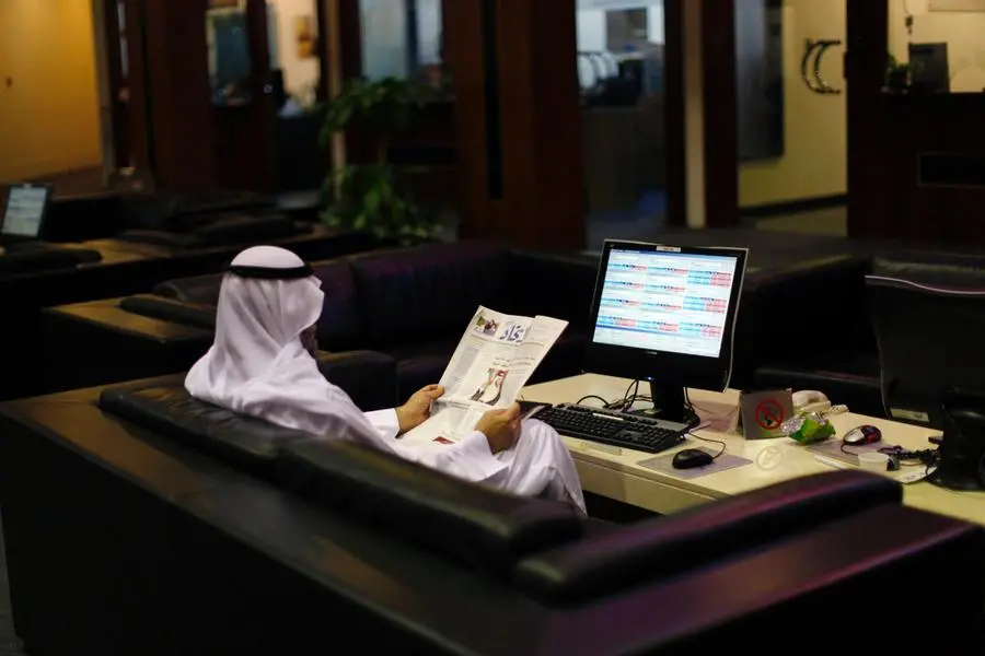 An investor reads a paper as he monitors a stock exchange information screen on the trading floor at the Dubai Financial Market April 29, 2012. , Reuters/Jumana El Heloueh 