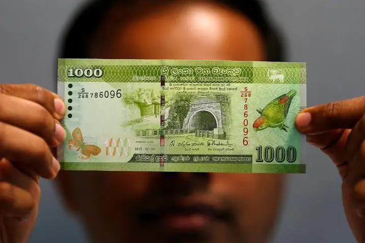 A man shows a thousand rupee note in this illustration photo taken September 7, 2018. , Reuters Images/Dinuka Liyanawatte