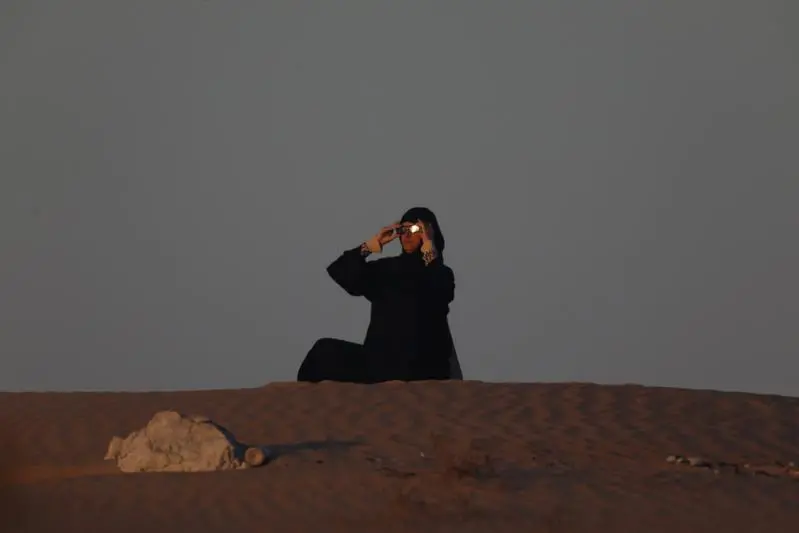 An Emirati woman views an annular solar eclipse in Madinat Zayed in the Al Dhafra region of Abu Dhabi, United Arab Emirates, December 26, 2019.  , Reuters Images/Christopher Pike 