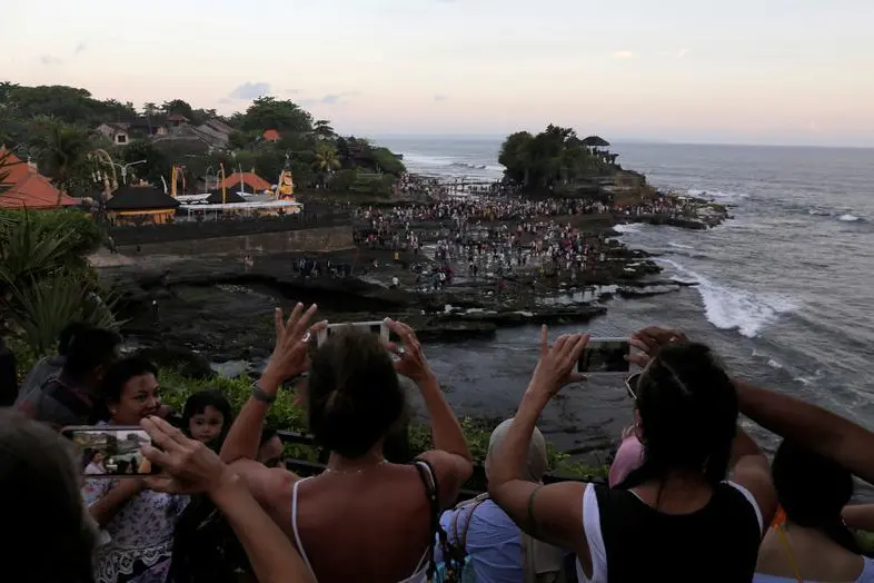 Tourists take pictures of the Hindu temple Tanah Lot (R) in Tabanan, on the resort island of Bali, Indonesia May 6, 2018.  , Reuters Images/Johannes P. Christo 