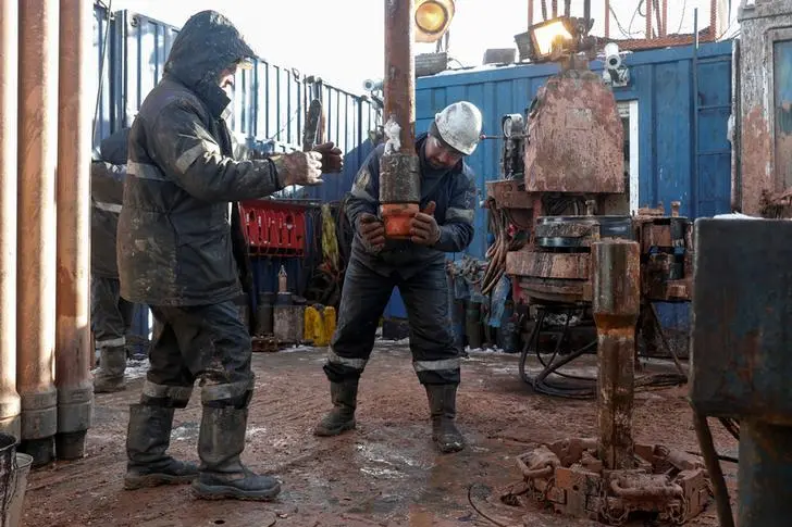 Drilling crew members move a pipe while working at an oil rig in the Yarakta Oil Field, owned by Irkutsk Oil Company (INK), in Irkutsk Region, Russia March 11, 2019.  , Reuters Images/Vasily Fedosenko