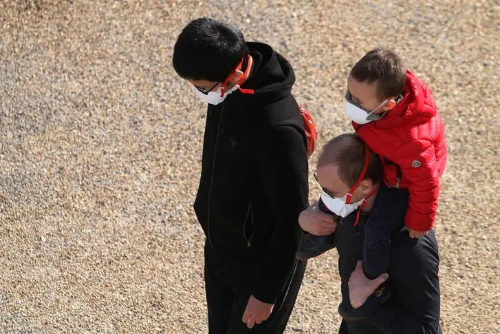 People walk by the River Thames with a child wearing protective face masks in Silvertown, East London as the spread of the coronavirus disease (COVID-19) continues, in London, Britain, April 21, 2020. , Reuters Images/Steven Watt