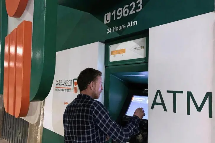 A man withdraws money from an ATM machine at the National Bank of Egypt (NBE) in Cairo, Egypt, April 23, 2020.  , Reuters Images/Mohamed Abd El Ghany