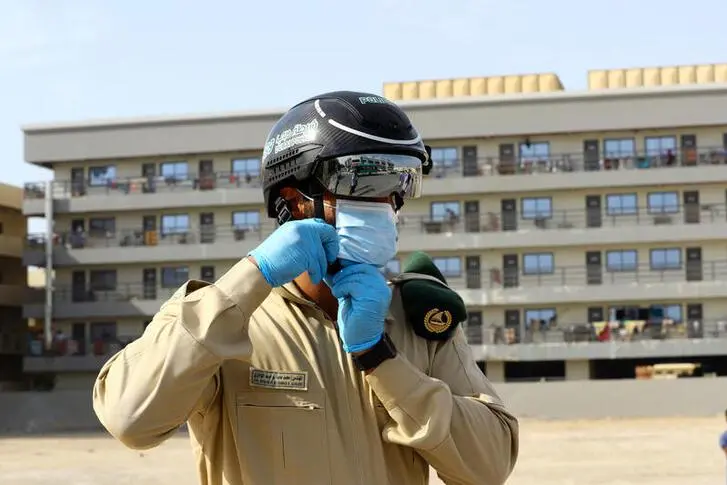 A police officer wears a smart helmet as he uses it to test the temperature of the workers during the outbreak of the coronavirus disease (COVID-19) in Dubai, United Arab Emirates April 23, 2020.  , Reuters Images/Ahmed Jadallah