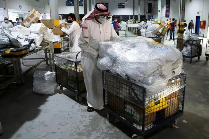 A Saudi employee wears a face mask as he sorts out boxes at the warehouse of Naqel Company Express, after the announcement of the easing of lockdown measures amid the coronavirus disease (COVID-19) outbreak, in Riyadh, Saudi Arabia June 9, 2020.  , Reuters Images/Ahmed Yosri