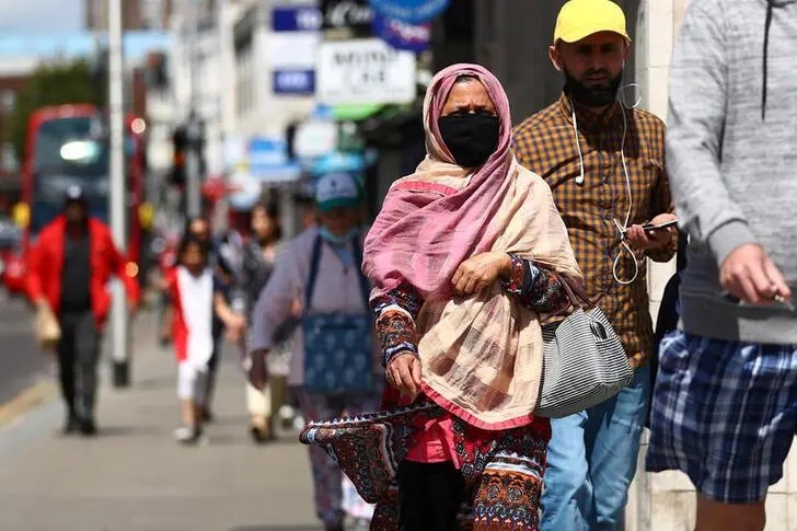People walk down a street following the coronavirus disease (COVID-19) outbreak, in Ilford, London, Britain July 29, 2020.\\r\\nImage used for illustrator purpose , Reuters Images/Hannah McKay