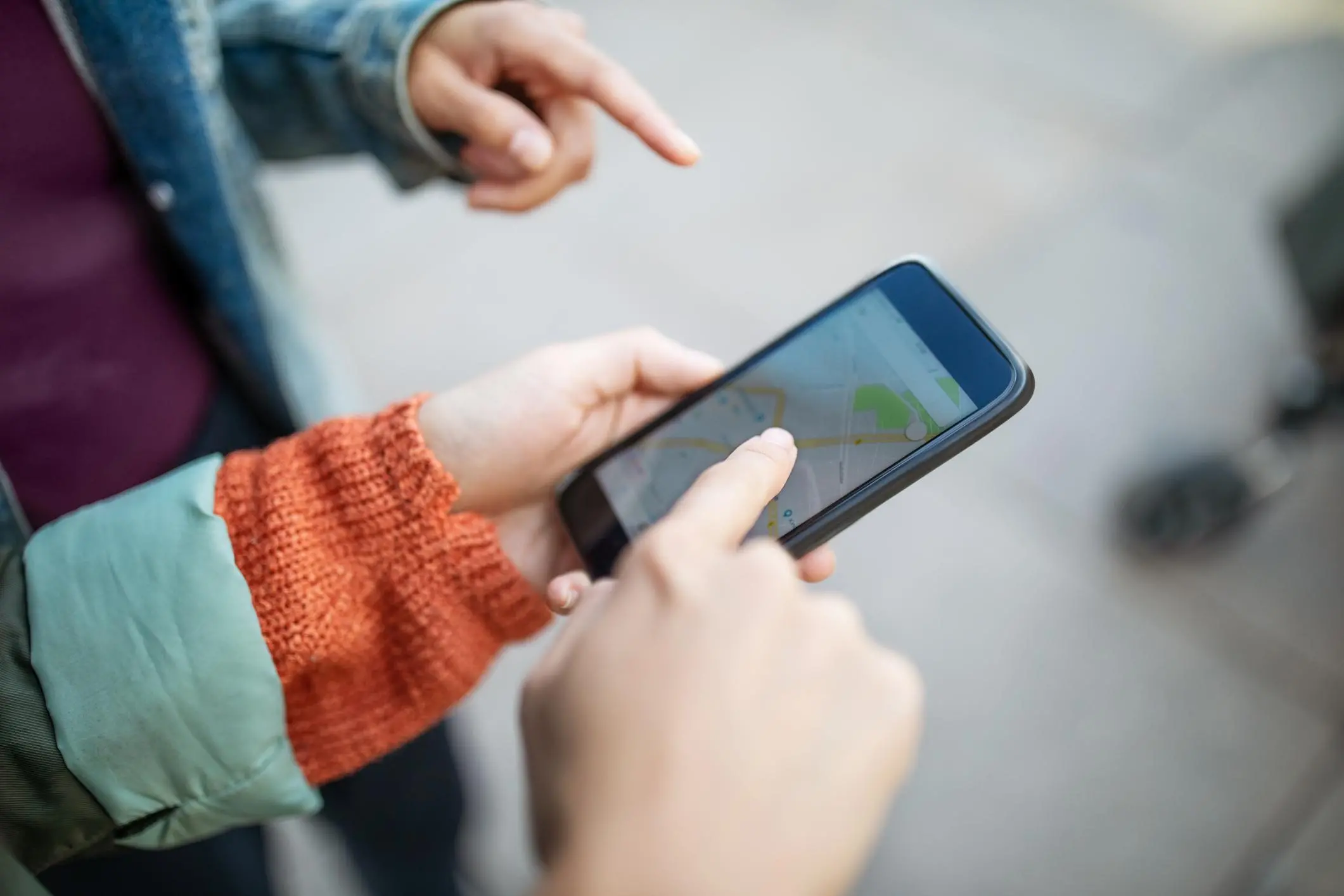 Woman pointing at map on smart phone while traveling in city during vacation.\\r\\nImage used for illustrative purpose. , Getty Images