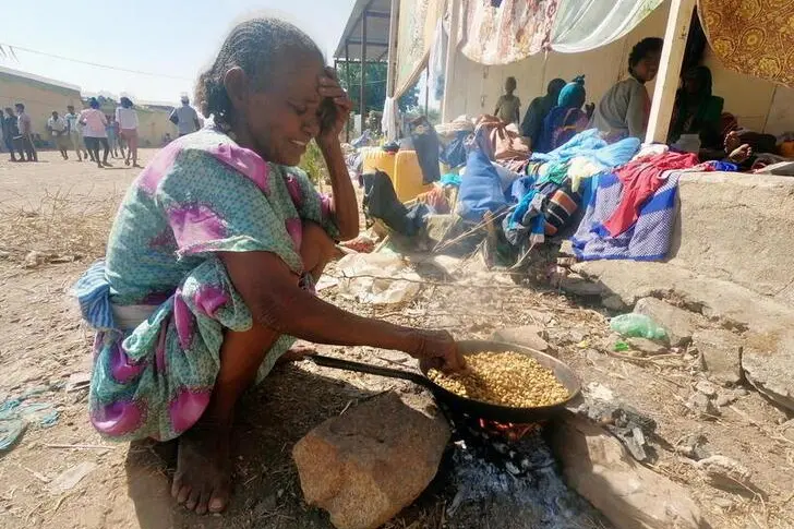 An Ethiopian who fled the ongoing fighting in Tigray region, prepares a meal in Hamdait village on the Sudan-Ethiopia border in eastern Kassala state, Sudan November 14, 2020. , Reuters Images/El Tayeb Siddig